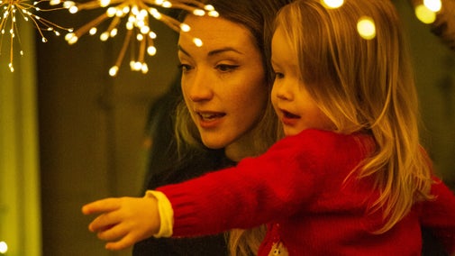 A mum and her young child enjoy twinkling festive lights.